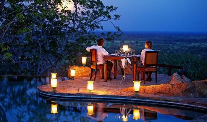 Romantic candlelit dinner setup in the African bush for a luxury safari honeymoon