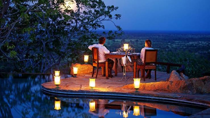 Romantic candlelit dinner setup in the African bush for a luxury safari honeymoon