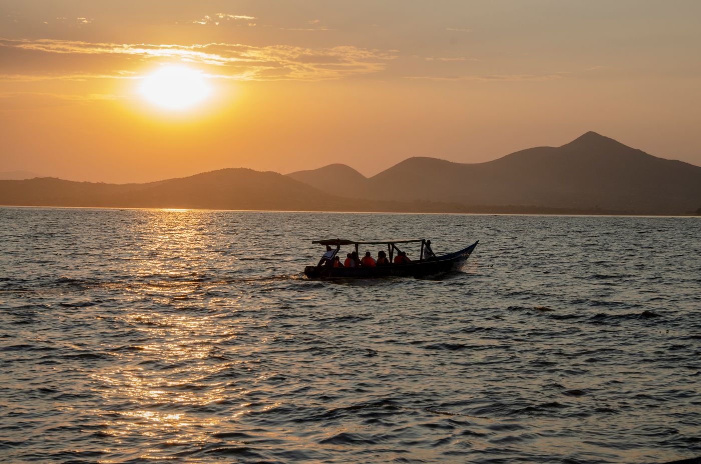 Tourists on a boat ride on a Kenyan lake at sunset